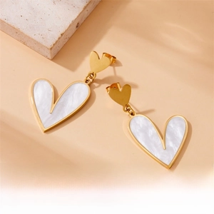 Detailed view of gold stainless steel earrings with white shell heart-shaped pendants