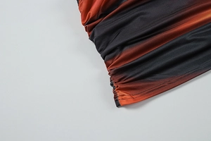 Detail of ruched fabric with a sunset black to orange gradient on summer skirt set