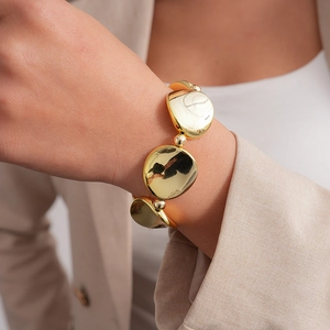 Detailed close-up of a vintage minimalist gold bracelet with polished irregular metal discs