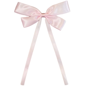 Detailed view of a soft pink ribbon hair bow with elegant satin finish on white background