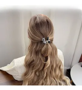 Vue détaillée d'une pince à cheveux motif marbre portée sur une coiffure demi-queue
