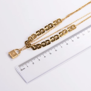 Detailed size measurement of golden layered chain bracelet with lock charm on white background