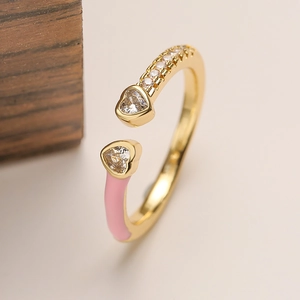 Dettaglio del cuore in smalto rosa e zircone su un anello aperto placcato oro da donna