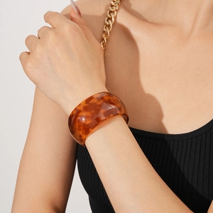Detail of translucent tortoiseshell resin cuff bracelet with polished rounded edges