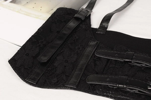 Close-up of black lace waist belt with faux leather straps and metal buckle details