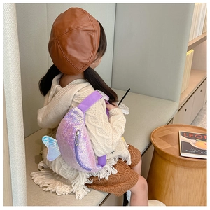 Close-up of a child wearing a purple sequin mermaid tail fanny pack over a beige sweater