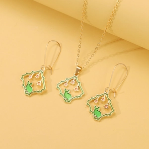 Detail of gold-plated necklace and earrings set featuring green enamel rabbit charms