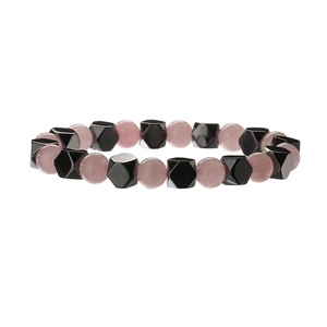 Détail de perles rondes roses et de pierres facettées noires sur un bracelet perlé