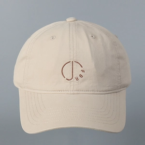 Close-up of beige washed cotton baseball cap featuring circular FBR letter embroidery