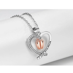 Detail of silver heart pendant with rose gold baby footprints and I love you mom engraving