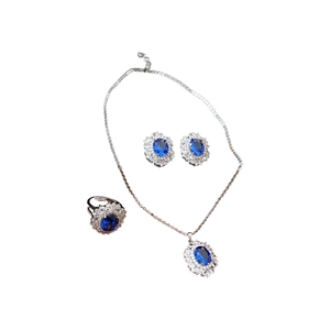 Set di gioielli vintage con gemme ovali blu navy e diamanti su sfondo bianco