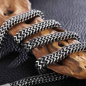 Macro shot of silver titanium steel chain wrapped on textured wood for men necklace