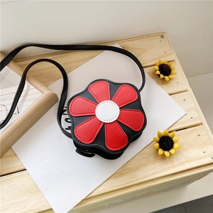 Detailed top view of black flower shaped crossbody bag for girls with red petals on wood