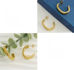 Detailed macro view of gold-plated C-shape earrings with vertical ribbed texture