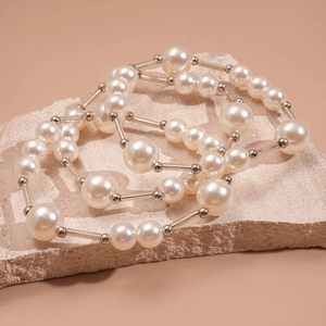 Détail du collier de perles vintage à trois couches avec cylindres sur fond de pierre