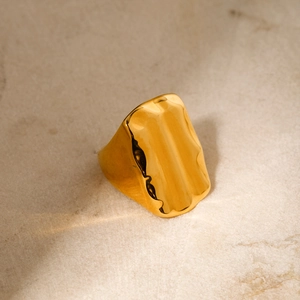 Bague en acier inoxydable plaqué or 18 carats avec texture martelée sur fond de pierre neutre