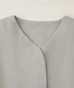 Detailed view of the classic V-neckline and high-density twill fabric on grey blazer