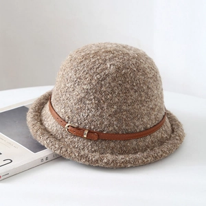 Chapeau cloche en polaire marron avec boucle en cuir sur une surface blanche