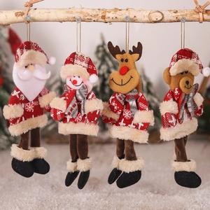 Detail of plush Christmas tree ornaments featuring Santa, snowman, elk and bear hanging on wood