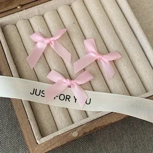 Close-up of three pink satin ribbon bows inside a jewelry box for hair DIY projects