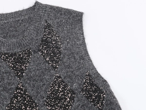 Detailed close-up of grey knit vest featuring silver sequin diamond patterns