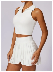 Side view of white sleeveless polo top and pleated tennis skirt set on female model
