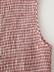 Detailed macro view of red and white gingham fabric with elastic smocked texture and pattern