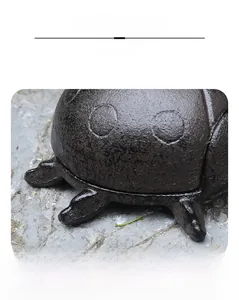 Macro detail of vintage cast iron ladybug key box showing bronze textured finish