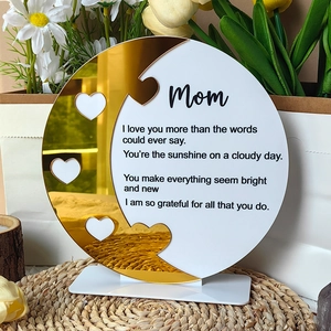 Macro detail of acrylic Mom gift plaque with gold mirror finish and engraved heart cutouts