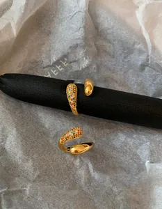 Macro detail of gold plated crisscross ring with colorful teardrop micro-inlaid stones