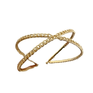 Golden crossed-link metal headband with twisted chain texture and ball-end accents