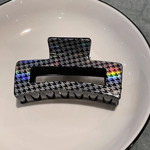 Close-up of holographic houndstooth pattern on a rectangular black hair claw clip