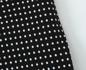 Detailed view of the classic black and white polka dot fabric with smooth texture