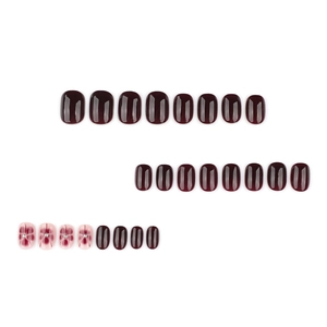 Short square burgundy false nails set with floral ink patterns and silver beads on white background