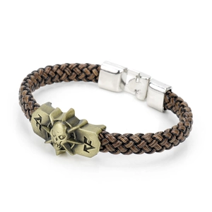 Detail of a brown braided rope bracelet with a bronze skull emblem and silver metal clasp