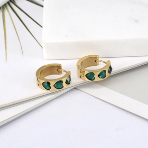 Detail showing gold hoop earrings featuring three inlaid green heart-shaped zircon stones
