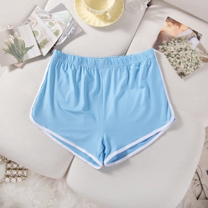 Detailed flat lay of light blue sports shorts with white trim on a textured surface
