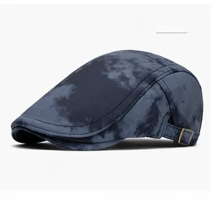 Detail view of navy blue flat cap featuring marble tie-dye texture and bronze metal buckle