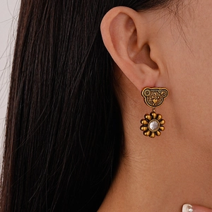 Detailed side view of vintage gold bear and daisy earrings featuring sparkling zircon stone