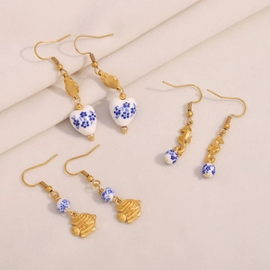 Three pairs of vintage 18K gold plated stainless steel fish earrings with blue floral beads