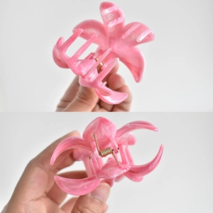 Detalle de pinza de pelo de flor de mármol rosa con un fuerte resorte de metal dorado