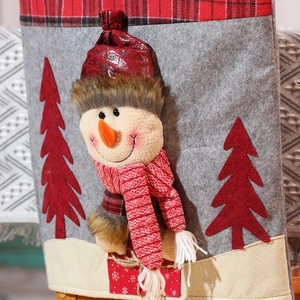 Close-up of 3D snowman figurine with knitted scarf and faux leather hat on chair cover