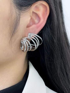 Close-up of stylish silver multi-layered hoop earrings with a geometric 3D design