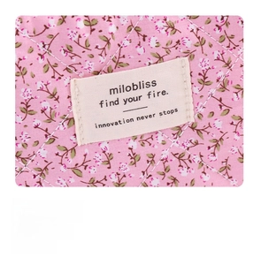 Detail of milobliss woven label on pink floral quilted fabric with neat stitching