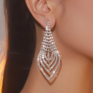 Detail of long V-shaped silver rhinestone tassel earrings worn on a model's ear