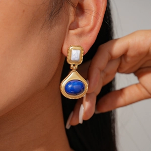 Detail von Vintage Goldohrringen mit weißen Struktursteinen und blauen ovalen Harzsteinen