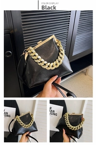 Detail of black lychee grain leather handbag with gold frame and chunky chain handle