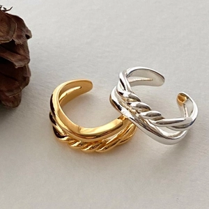 Detail of interlocking knot rings in gold and silver finish with twisted rope texture