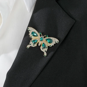 Vintage French butterfly brooch with emerald crystals on a black blazer lapel