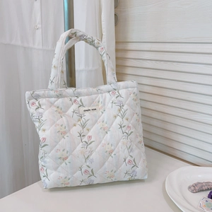 Detail of floral quilted tote bag with a woven Simple Wish label and stitching